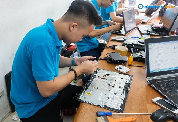 A technician is fixing laptop at SUACHUALAPTOP24h.com shop